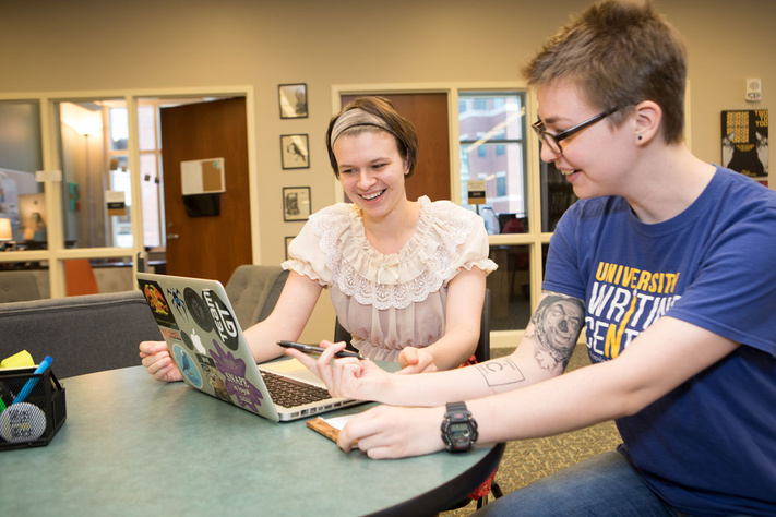 Students working in the writing center on laptop