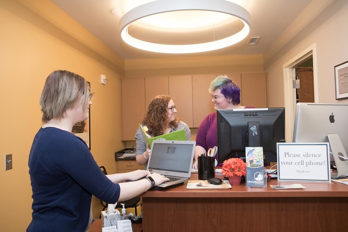 Person getting assistance at the writing center desk. 